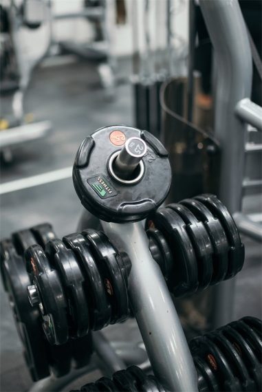 Manubri con dischi appoggiati sulla rastrelliera di una palestra